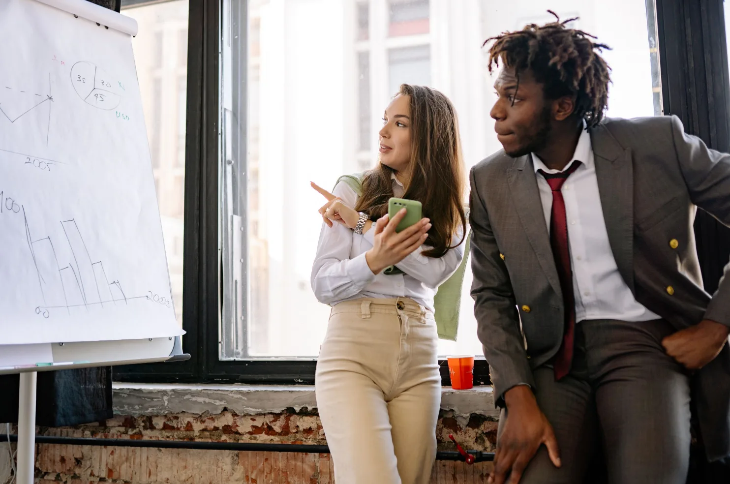 Two marketers mapping out a campaign plan on a board