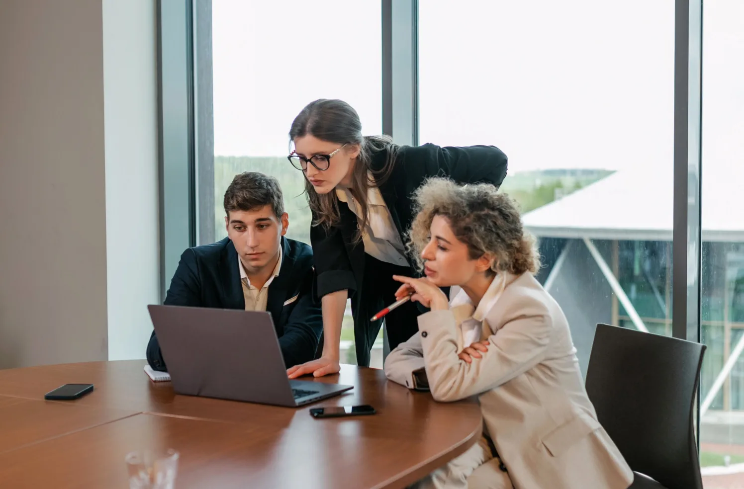 Team working through a marketing plan around a laptop